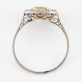 A ring in 18K white gold set with a yellow faceted tourmaline and rose-cut diamonds.