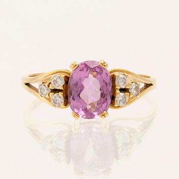 Ring 18K guld med oval fasetterad rosa ädelsten samt runda briljantslipade diamanter.
