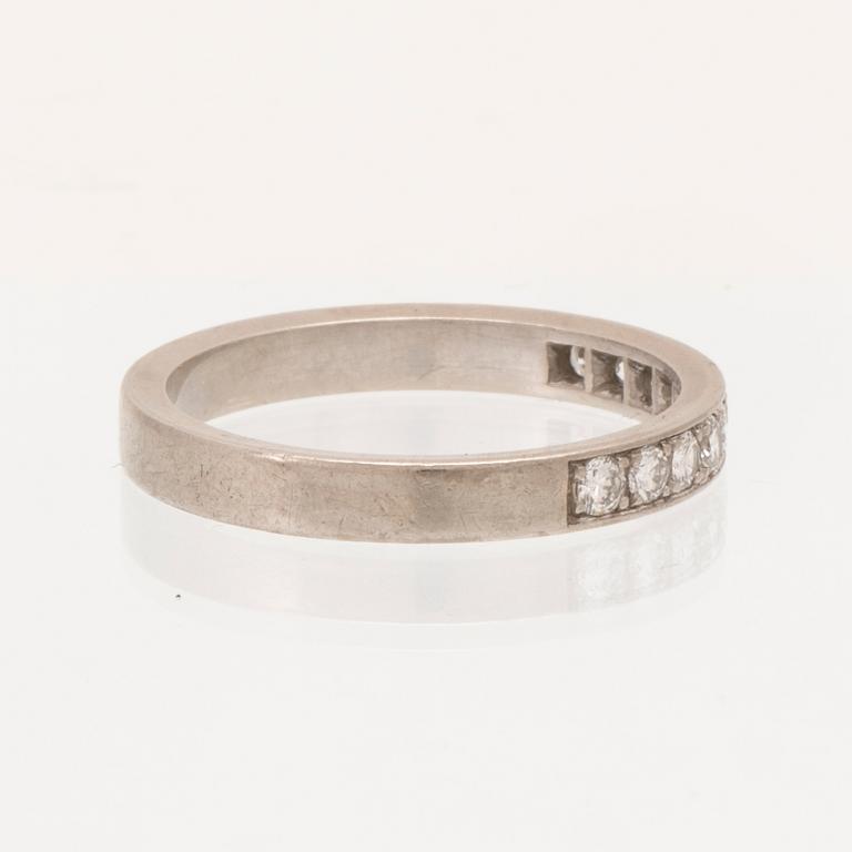 An 18K white gold half eternity ring set with round brilliant-cut diamonds.