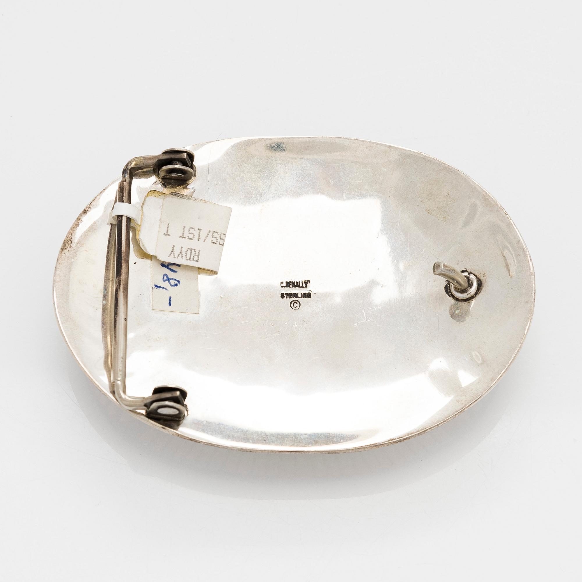 Chester Benally, a silver belt buckle with a turquoise, Navajo.