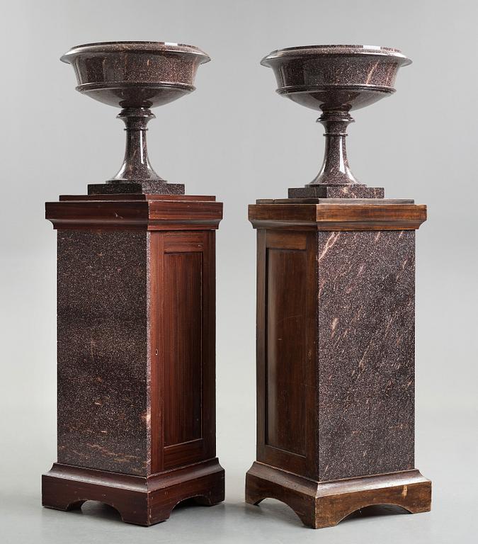 A pair of Swedish porpyry vases on wooden bases, Älvdalen, first half of the 19th century.