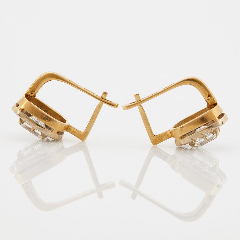 A pair of earrings in 18K gold set with emerald-cut diamonds.