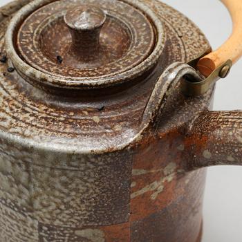 A tea pot and three tea cups in saltglazed stoneware by Christer Sjöblom, signed tea pot.