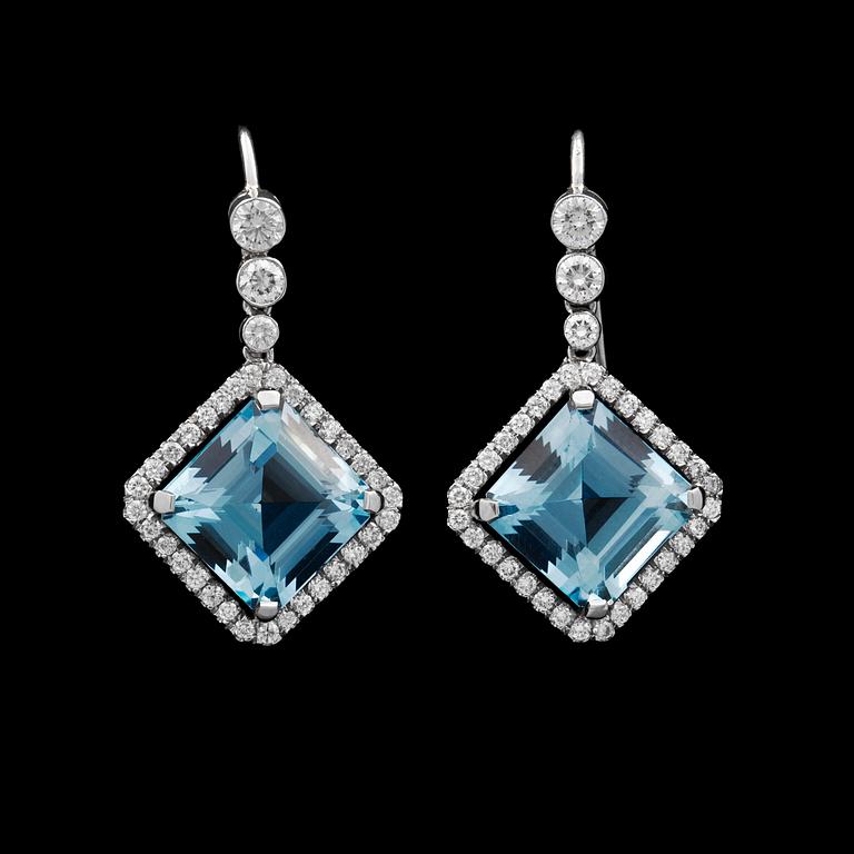 A pair of step cut aquamarine earrings set with brilliant cut diamonds.