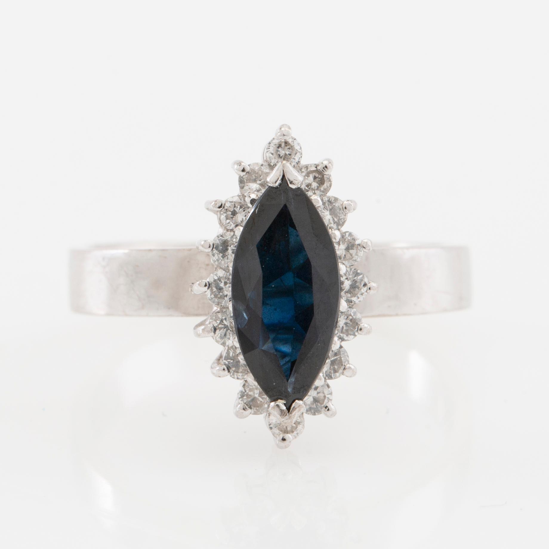 Ring 18K white gold set with a navette-cut sapphire and round brilliant-cut diamonds.