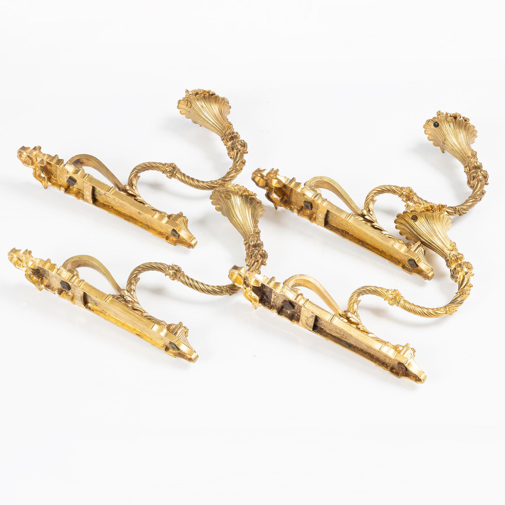 A set of four gilt bronze Louis XVI-style curtain holders, late 19th century.