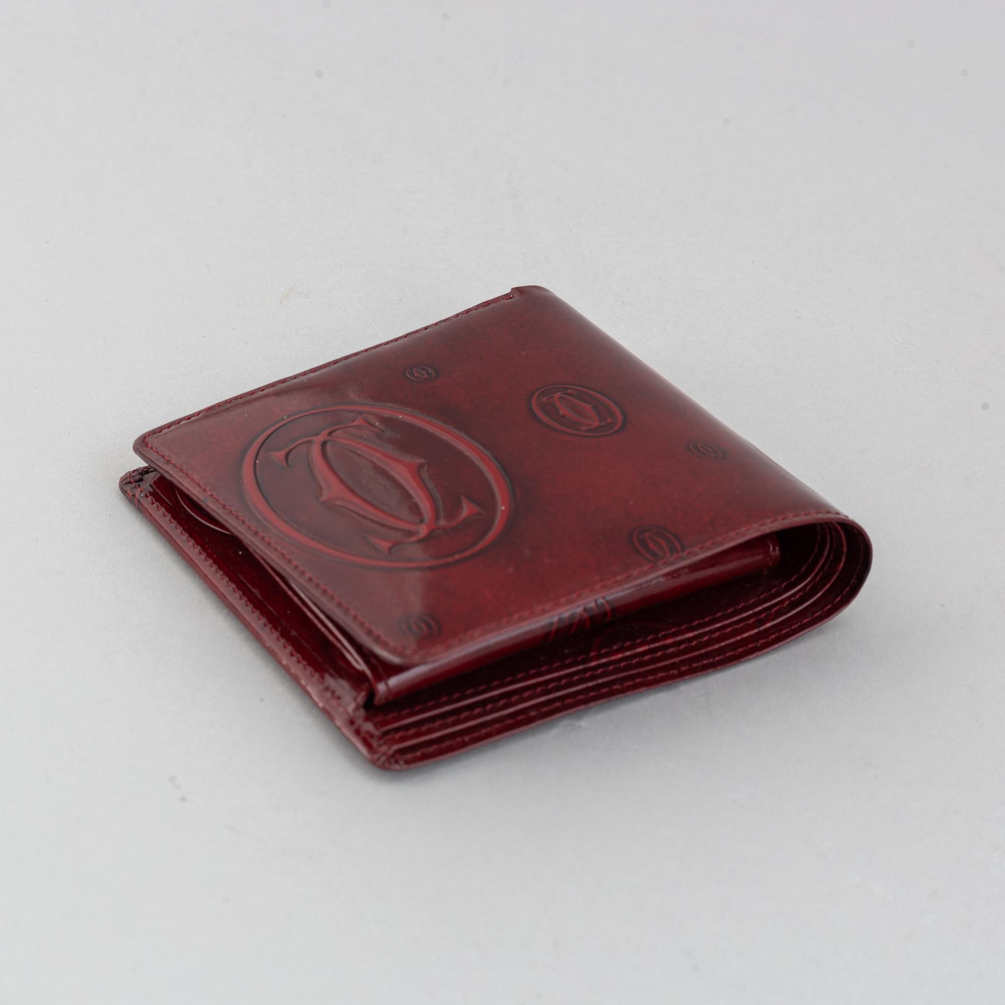 Cartier, a burgundy patent leather handbag and wallet.