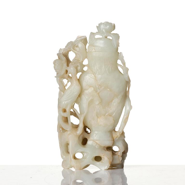 A well sculptured pale green and russet coloured nephrite vase with cover, 20th century.