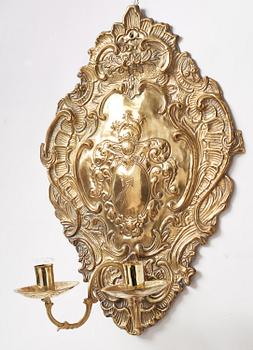 A pair of North European Rococo two-branch repoussé brass reflector plates, mid 18th century.