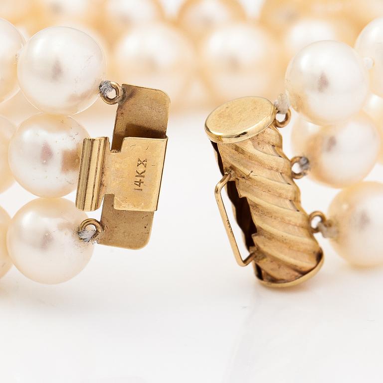 A three-strand pearl bracelet with cultured pearls and a 14K gold clasp.