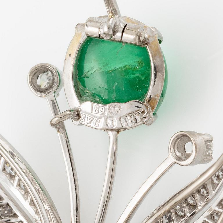 A brooch in 18K white gold with a cabochon-cut emerald.
