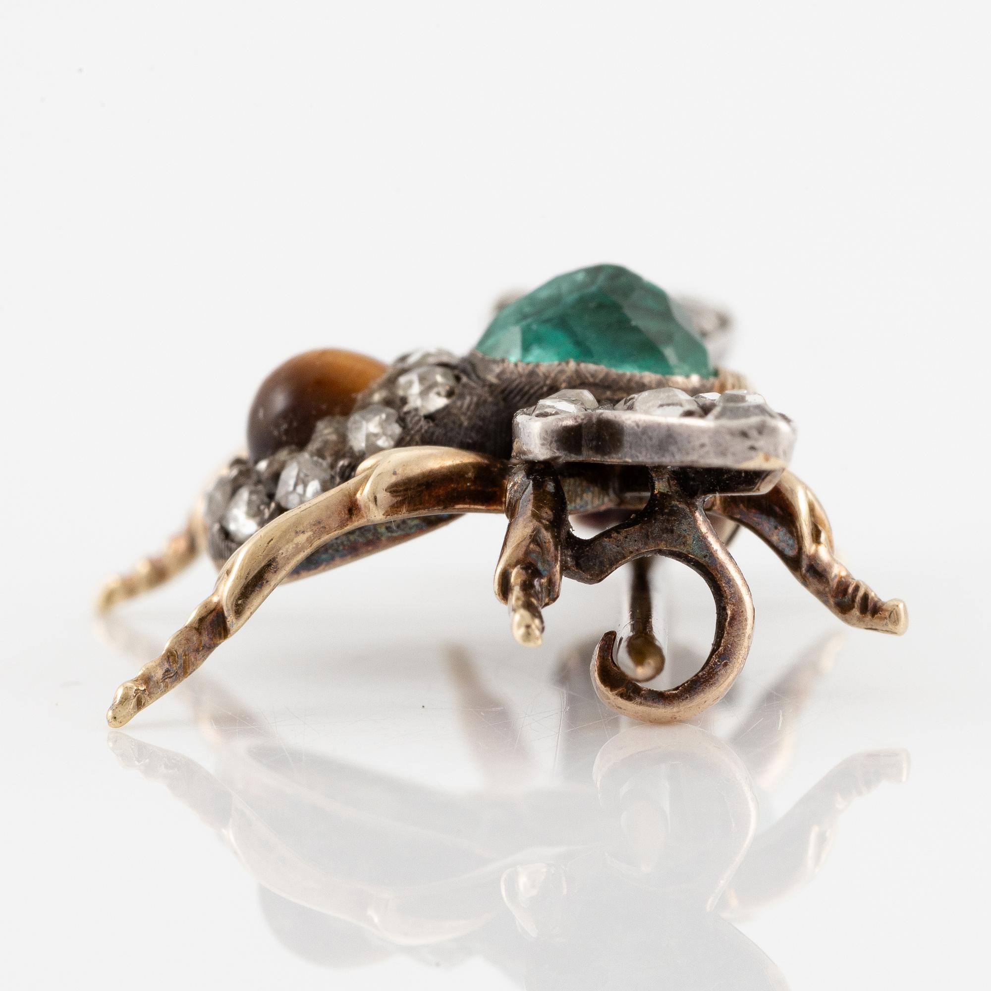 A brooch in silver and 14K gold with coloured gemstones and rose-cut diamonds.