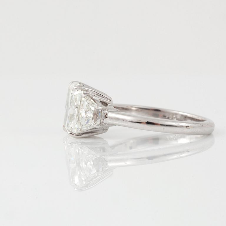 A cushion-cut diamond, 3.01 cts, flanked by two trapezoid-cut diamonds, 1.13 cts, ring.