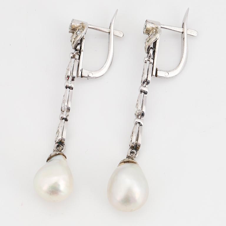 Diamond and pearl long white gold earrings.