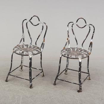a pair of modern iron graden chairs,