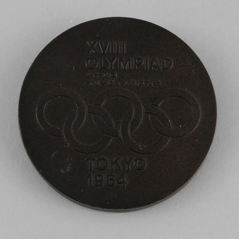 OLYMPISK DELTAGARMEDALJ, patinerad koppar, formgiven av Okamoto Taro, Tokyo, 1964.