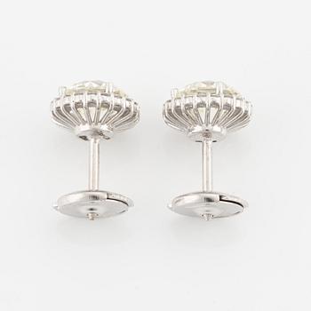 A pair of 18K gold earrings with round brilliant-cut diamonds.