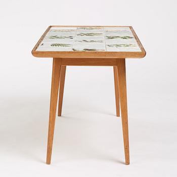 a Swedish Modern coffee table, decorated with Jobs' ceramic tiles, signed and dated 1941.