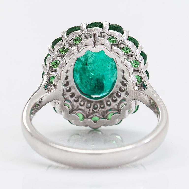 A 14K white gold ring with an emerald  2.33 ct, tsavorites 1.20 ct and diamonds ca 0.14 ct. With IGI certificate.