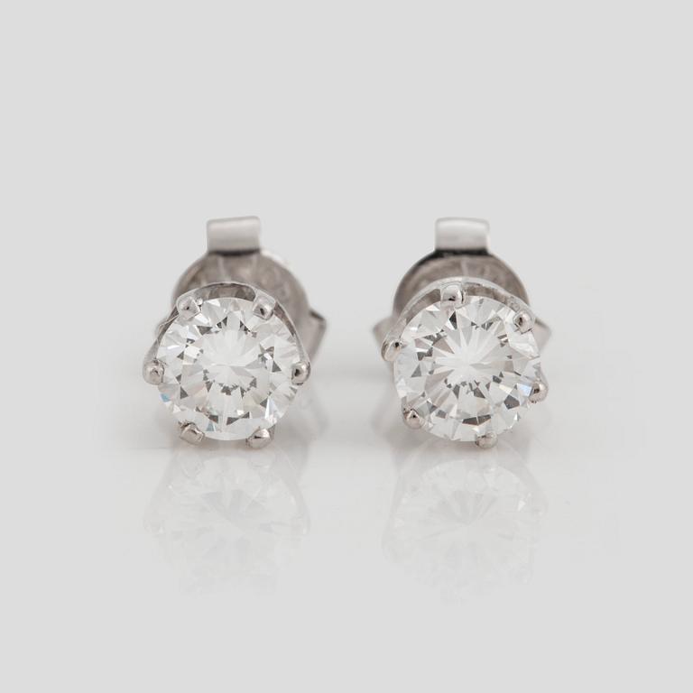 A pair of brilliant cut diamond earrings.