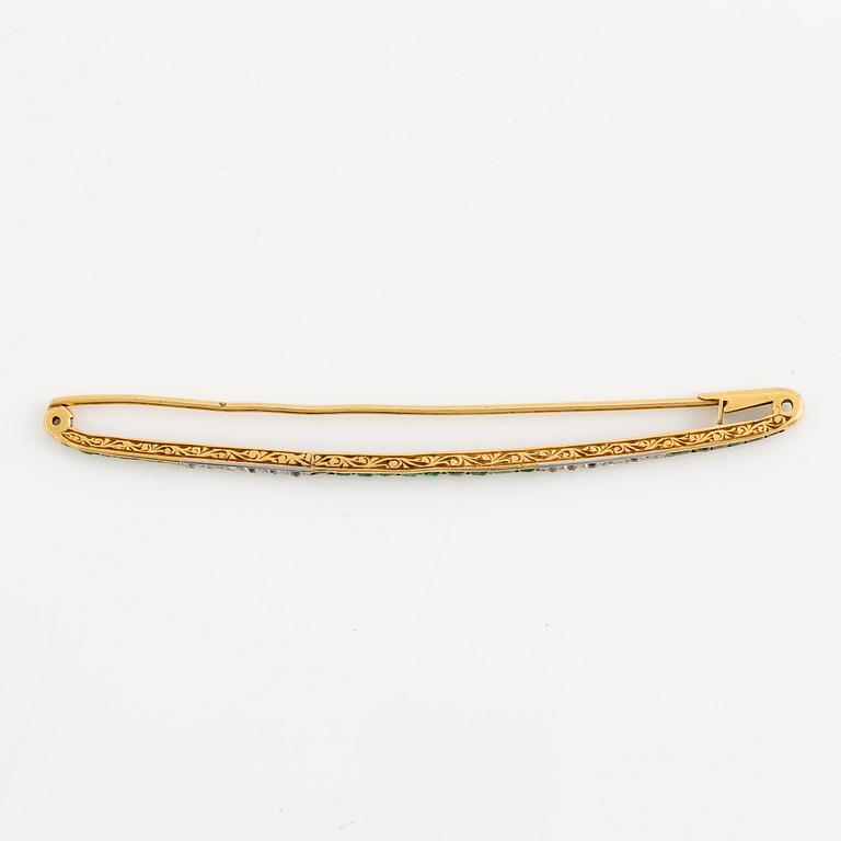 Brosch, längre modell, guld med carréslipade smaragder och gammalslipade diamanter, troligen omkring sekelskiftet 1900.