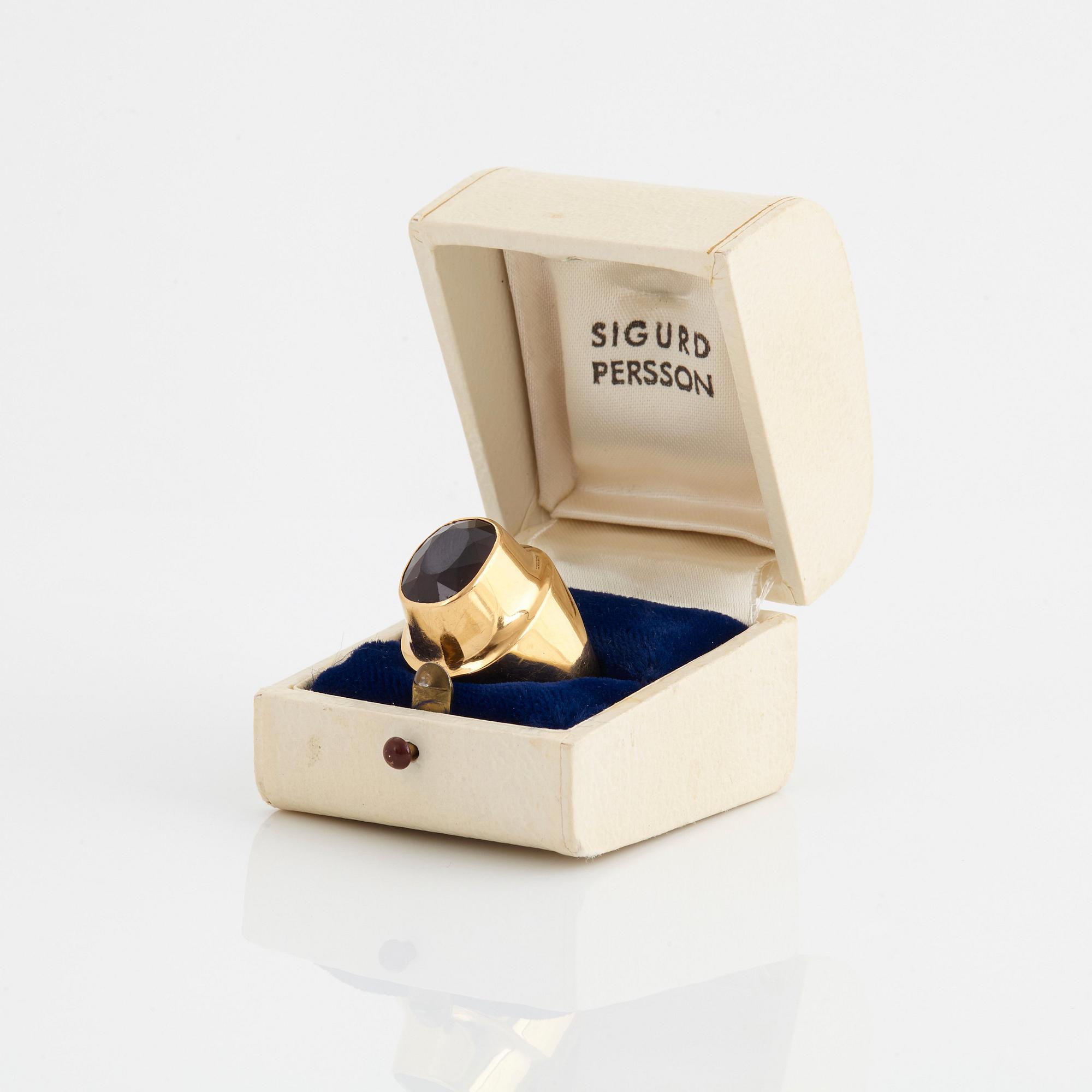 A Sigurd Persson 18K gold ring set with a faceted garnet.