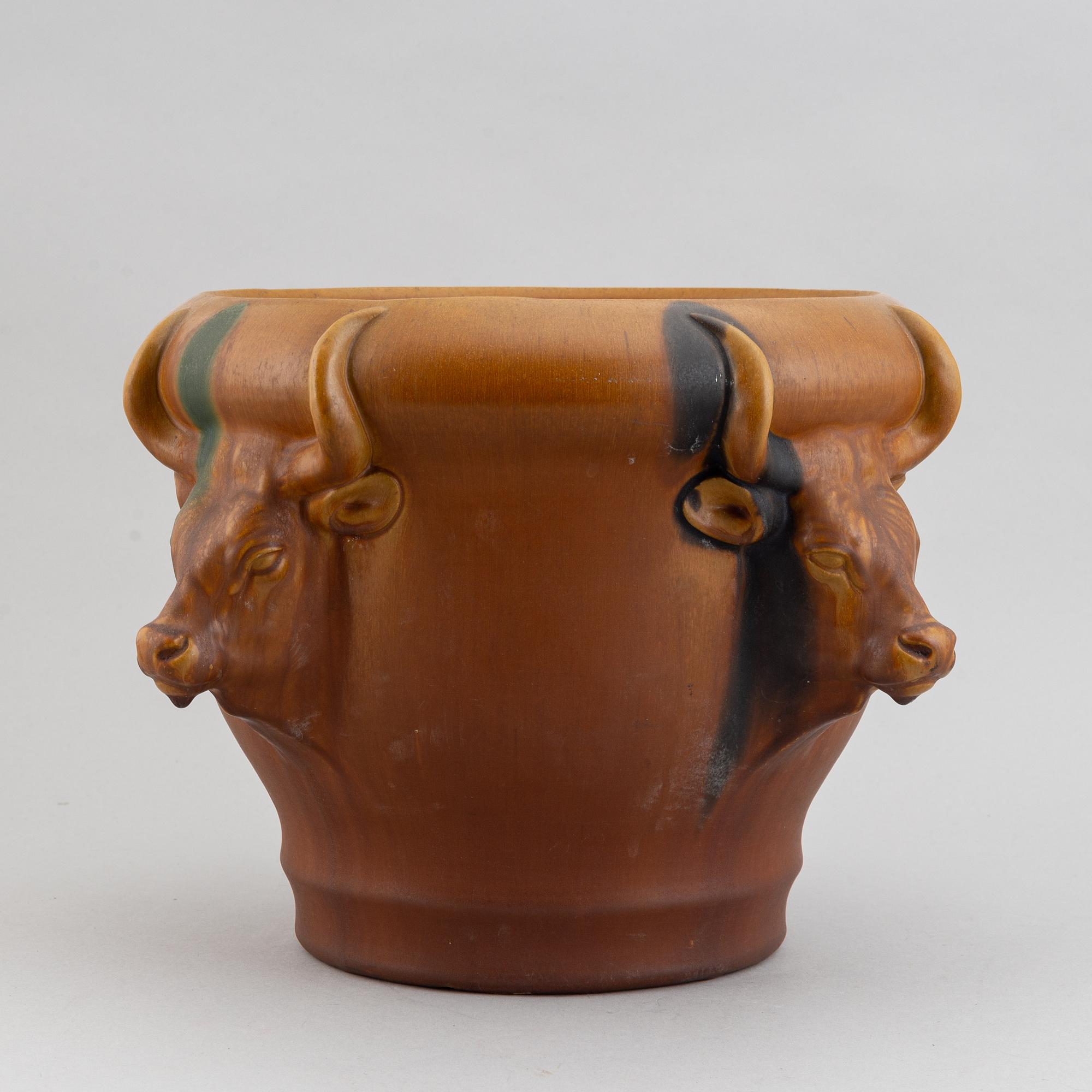 An earthenware pot decorated with four bulls heads. Probably by Karl Hansen Reistrup for Herman Kähler. Around 1900.