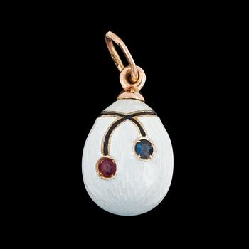 1059. A white enamel, ruby and sapphire pendant in the shape of an egg.