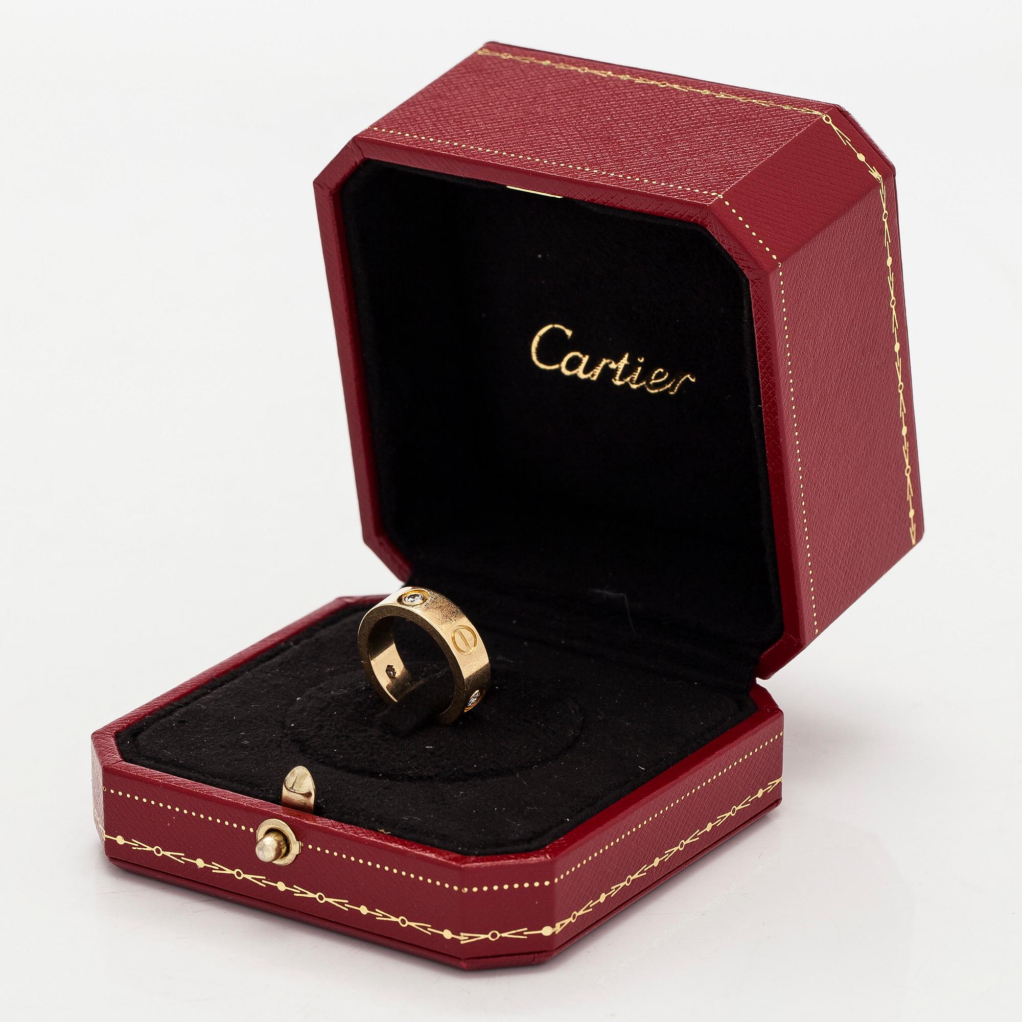 Cartier, an 18K gold 'Love' ring with three brilliant-cut diamonds.