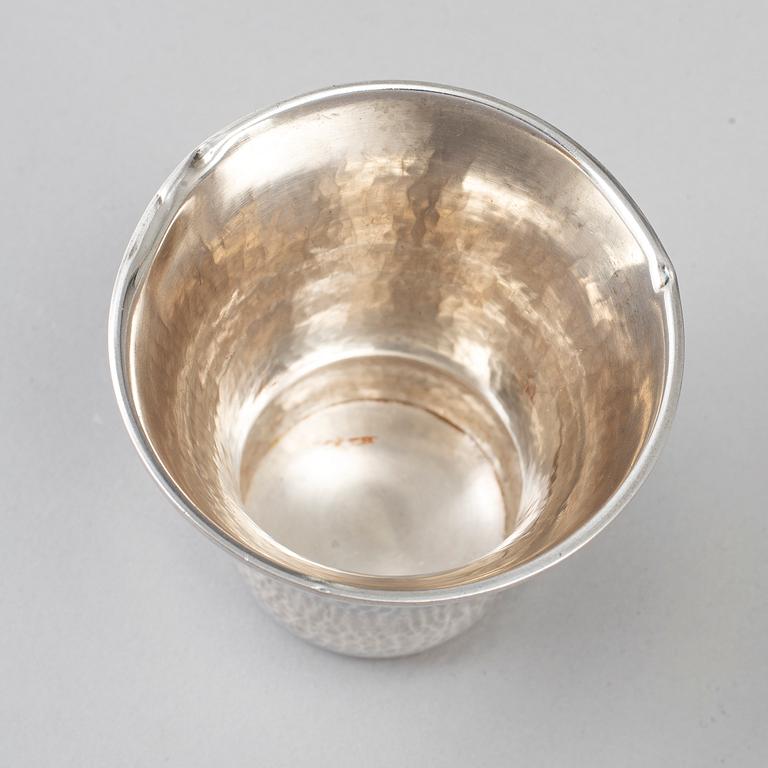 A silver vodkacup, lighter and matchholder.