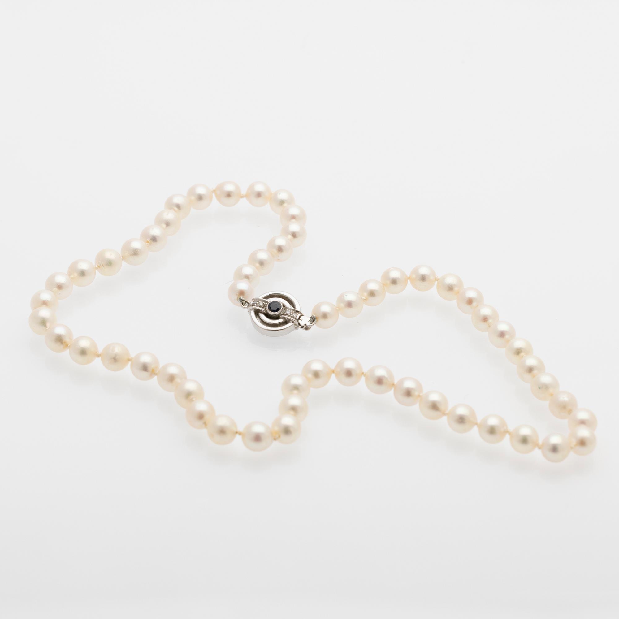 Pearl necklace, white gold clasp set with diamonds and a sapphire.