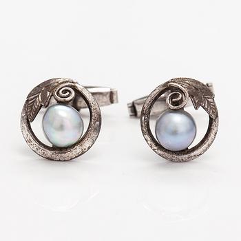 A pair of silver cufflinks with cultured baroque/Akoya pearls.