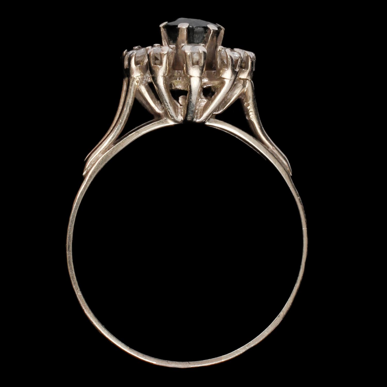 RING, 18k vitguld med fasettslipad blå safir samt 8 briljantslipade diamanter, 1900-talets tredje kvartal. Vikt 4 g.