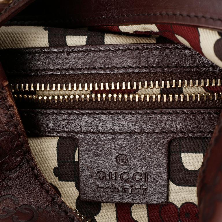 Gucci, a leather bag.