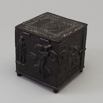 An empire cast iron tobacco box, dated 1838.