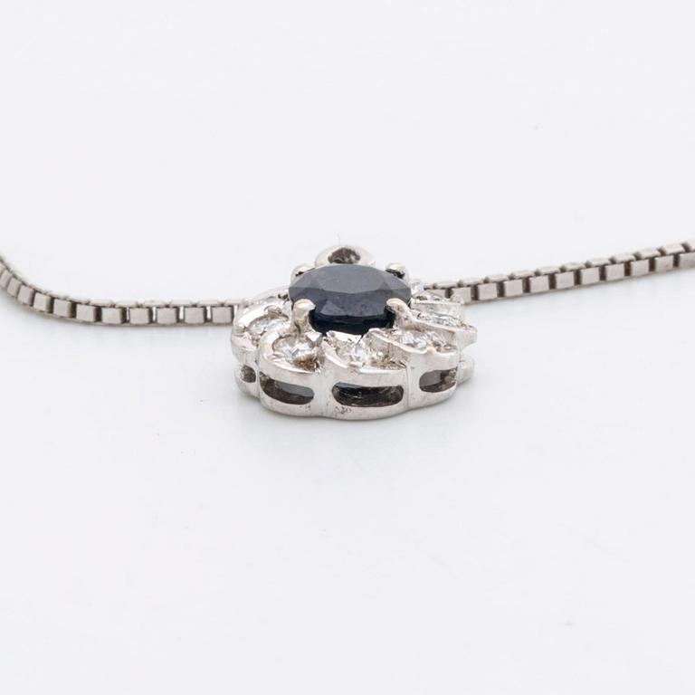 HÄNGE med kedja 18K vitguld 1 safir ca 6 x 4 mm samt 9 briljanter ca 0,25 ct totalt.