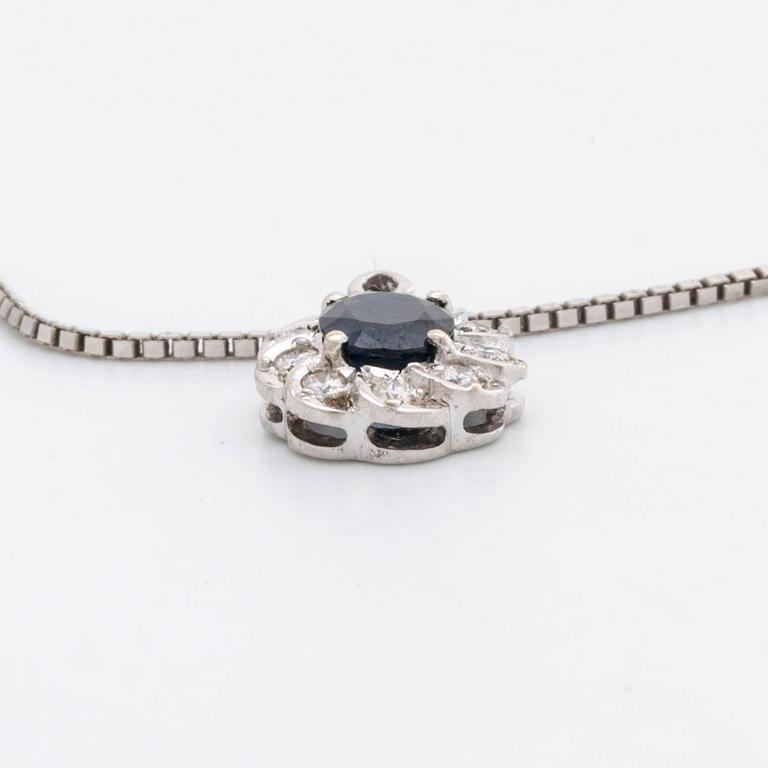 PENDANT and chain 18K whitegold 1 sapphire approx 6 x 4 mm and brilliant-cut diamonds approx 0,25 ct in total.