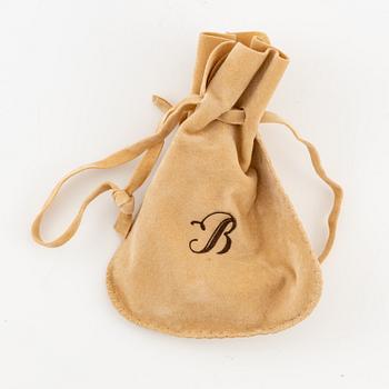 A brooch in platinum in the form of a bow with rubies and diamonds, likely from the 1950s.