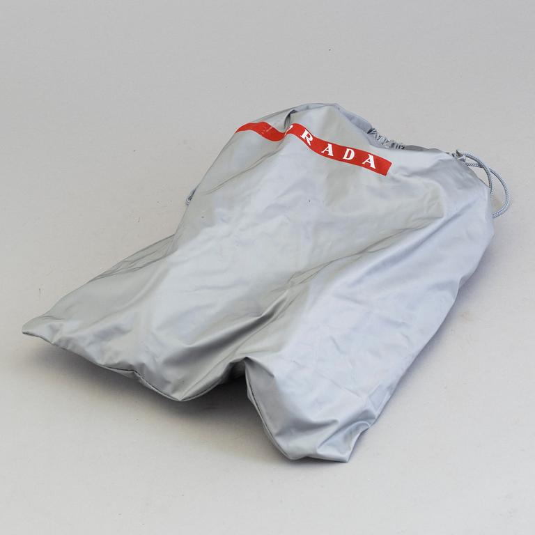 A pair of PRADA black patent leather sneakers.