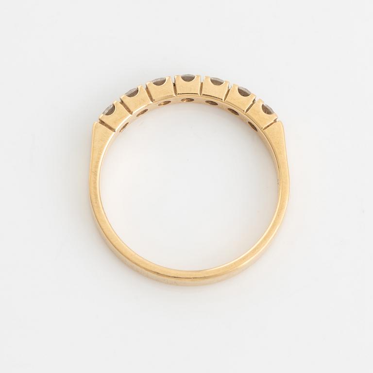 An 18K gold ring set with round briliiant-cut diamonds.