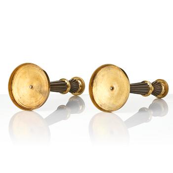 A pair of French Empire patinated and ormolu candlesticks, early 19th century.