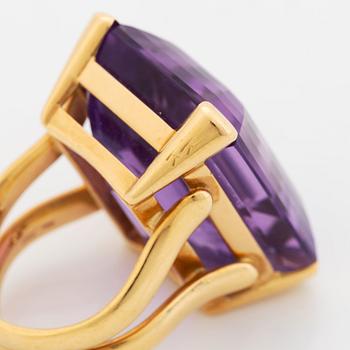 A Tina Karlsson ring in 18K gold set with a faceted amethyst.