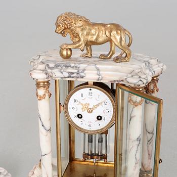 A Louis XVI style table clock and two urns, around the year 1900.