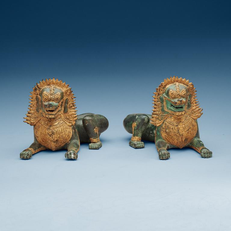 A pair of Burmese/Thai gilt bronze figures of buddhist lions, late 19th Century.