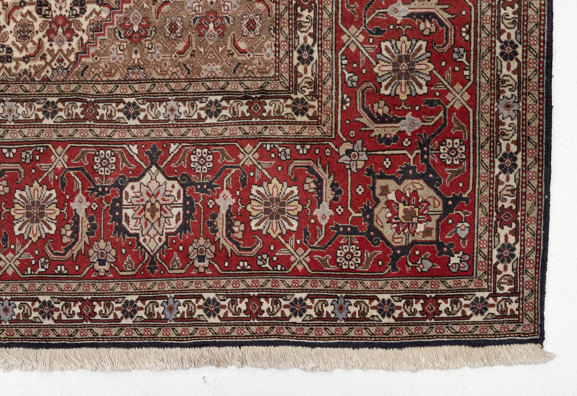 A signed Tabriz carpet, c. 385 x 300 cm.