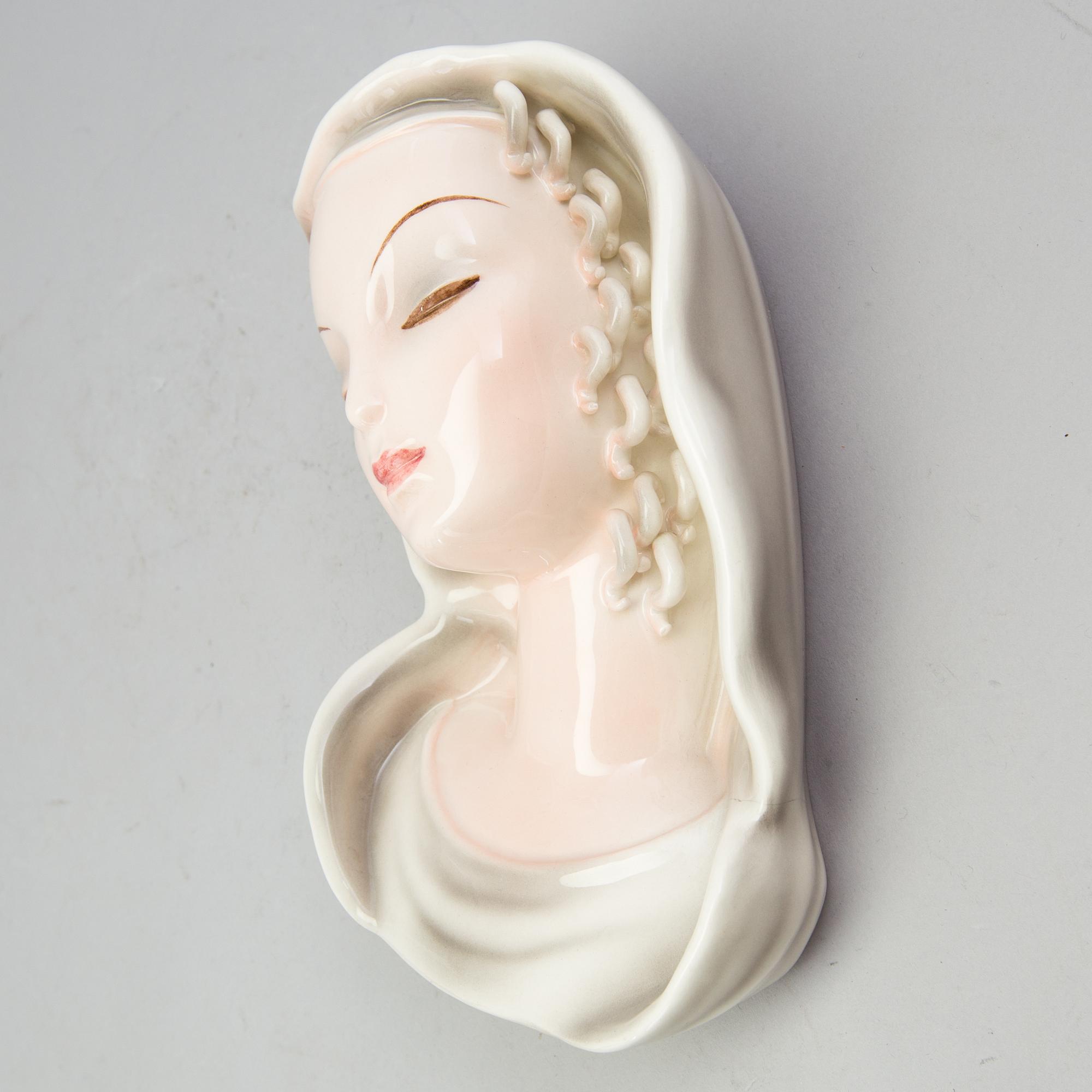 A late 1930s porcelain Goldscheider wall mask, model 7894, marked "Goldscheider Wien" and Made in Germany.
