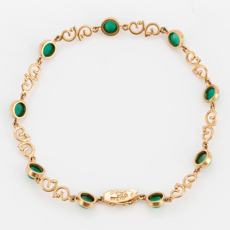 An 18K gold Ateljé Stigbert bracelet with cabochon-cut green stones.