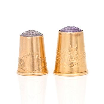Two 18K gold thimbles with blue and lilac stones.