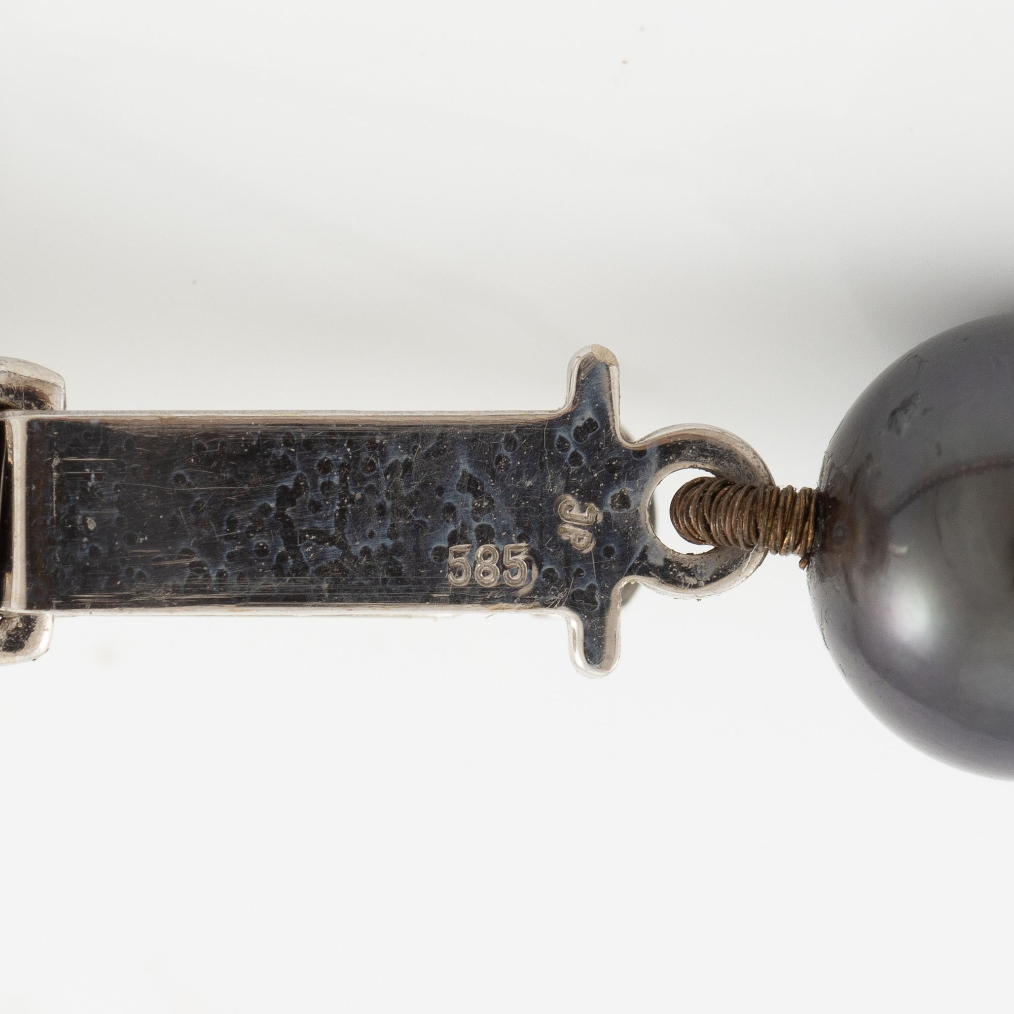 Necklace of cultured freshwater pearls, clasped with 14K white gold and round brilliant-cut diamonds.