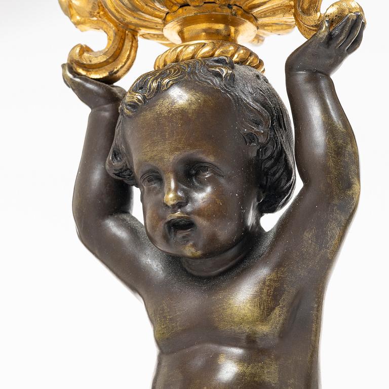 A Rococo style mantle clock and pair of candelabra, France, late 19th Century.